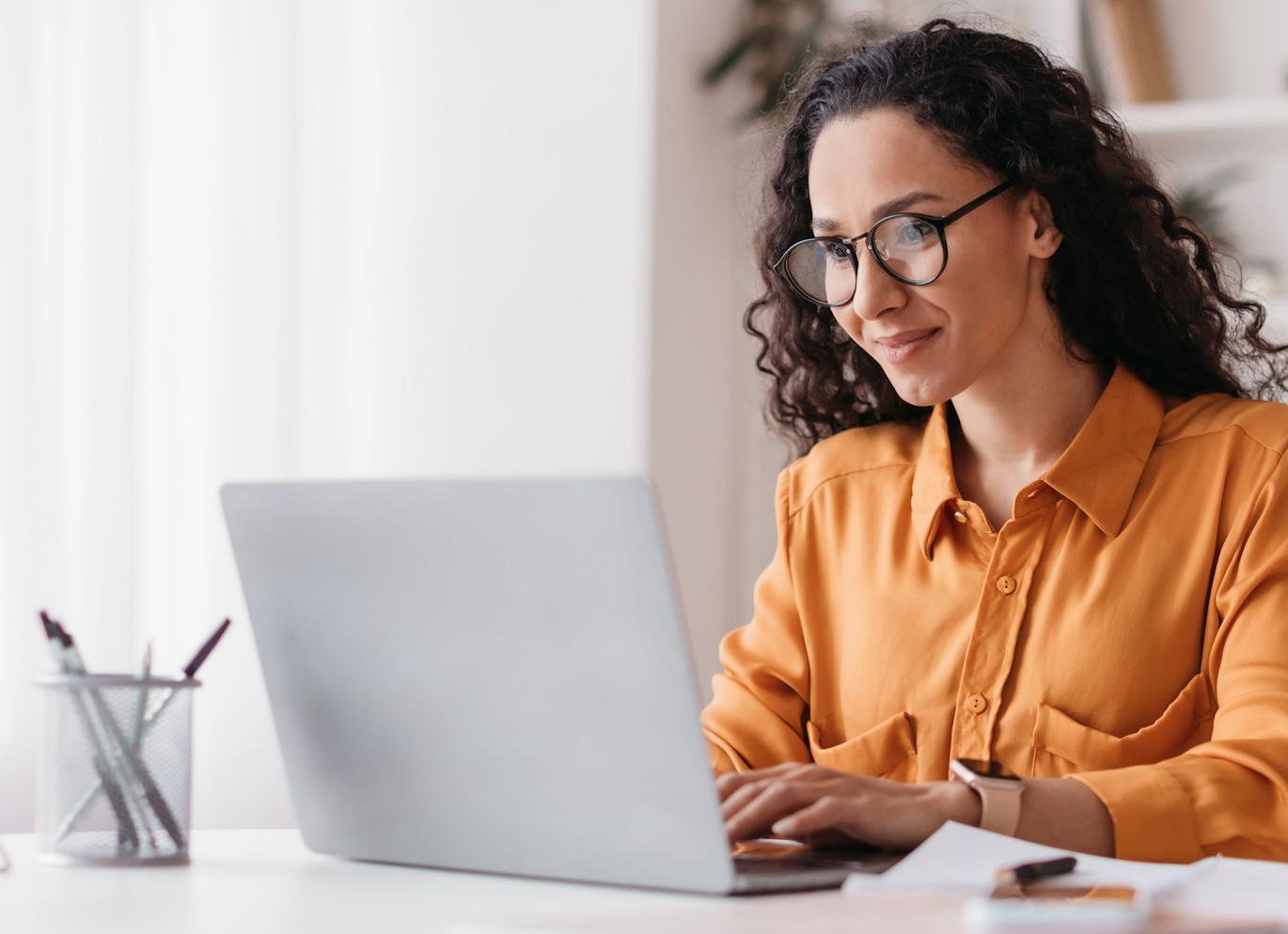 Women looking at laptop in orange shirt